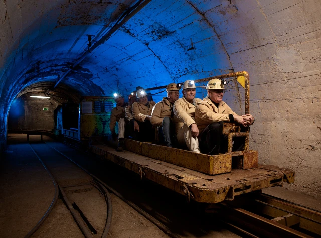 Bergleute fahren mit der Bahn im Stollen
