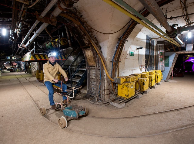 Ein Bergmann auf einem Grubenfahrrad unter Tage